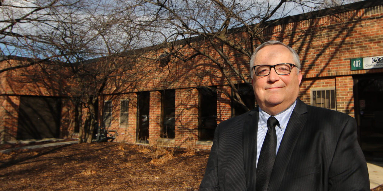 A man in suit and tie standing outside of a building.