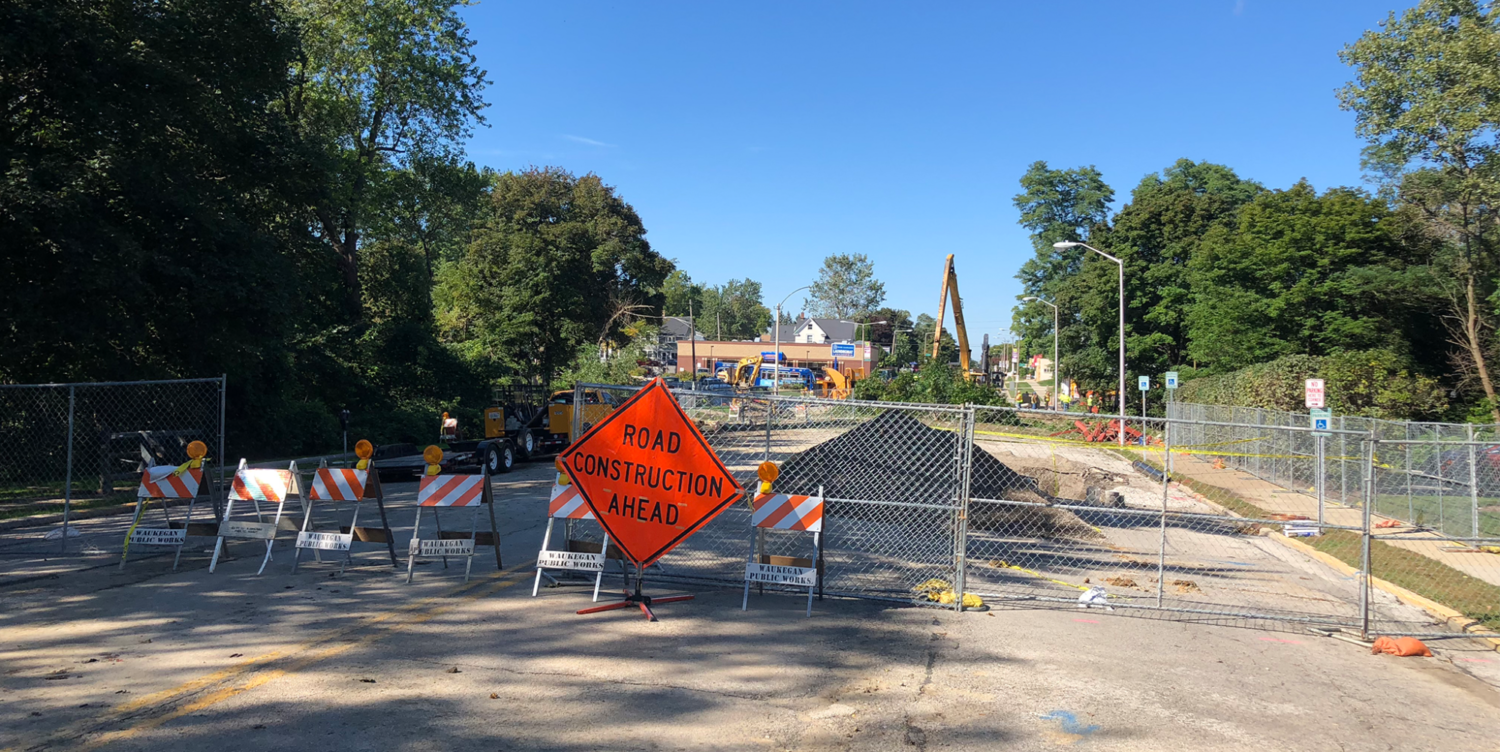 A construction site with orange and white signs.