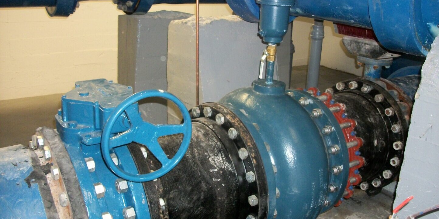 A blue and black pipe sitting next to pipes.