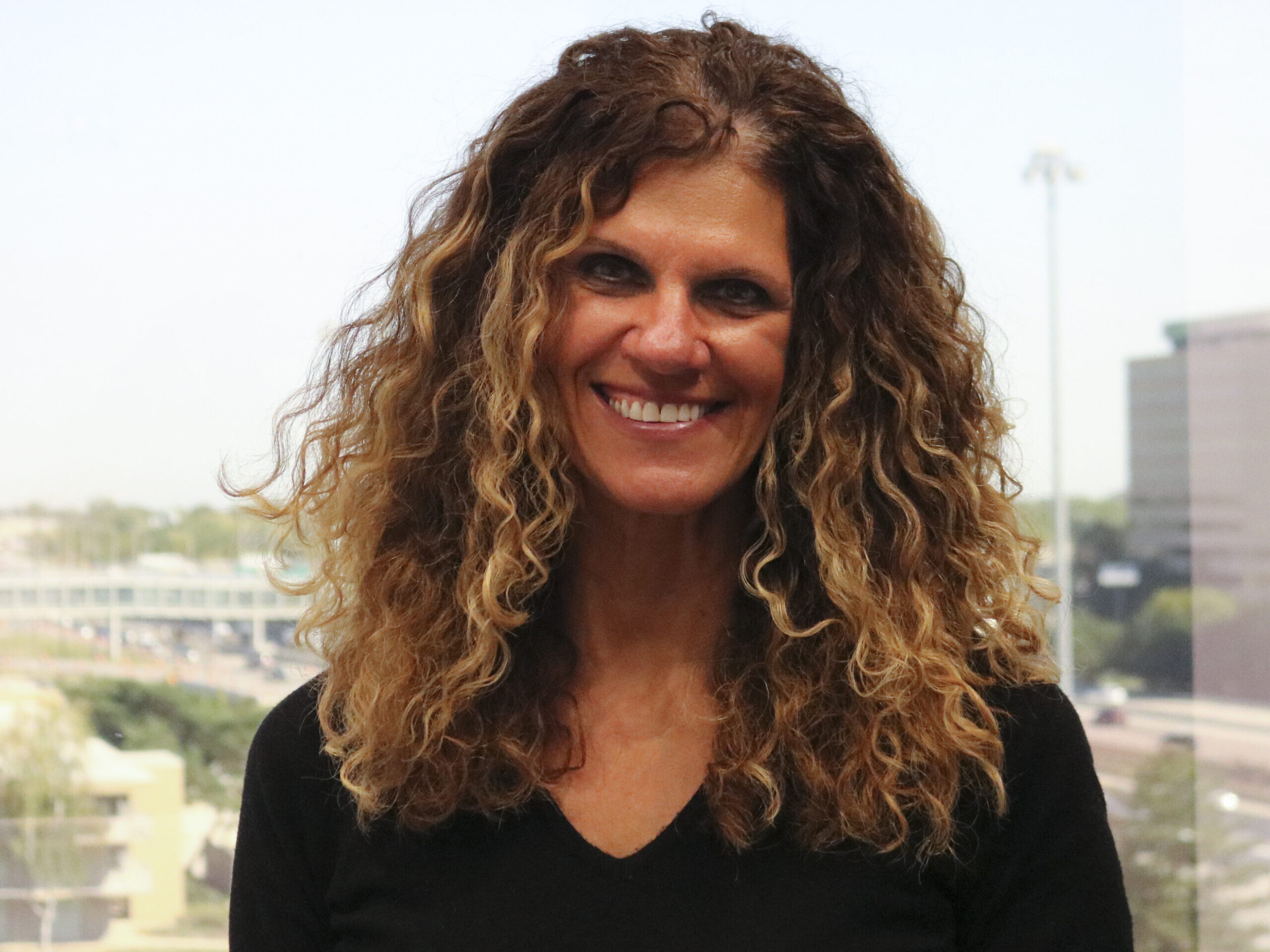 A woman with long hair and a black shirt