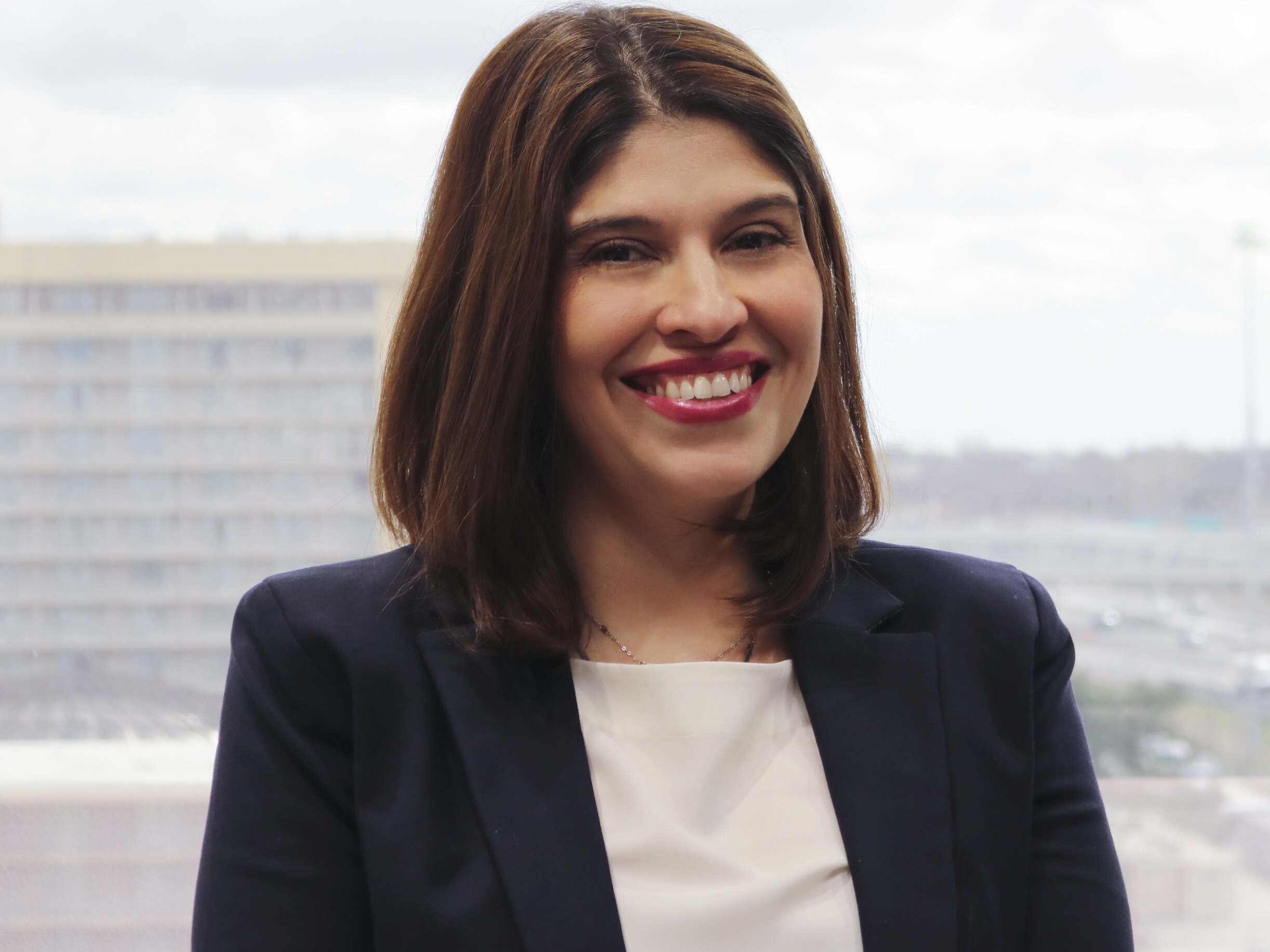 A woman in a suit smiling for the camera.