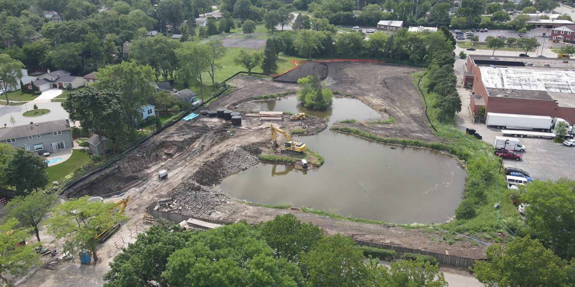 A large pond is being built in the middle of a field.