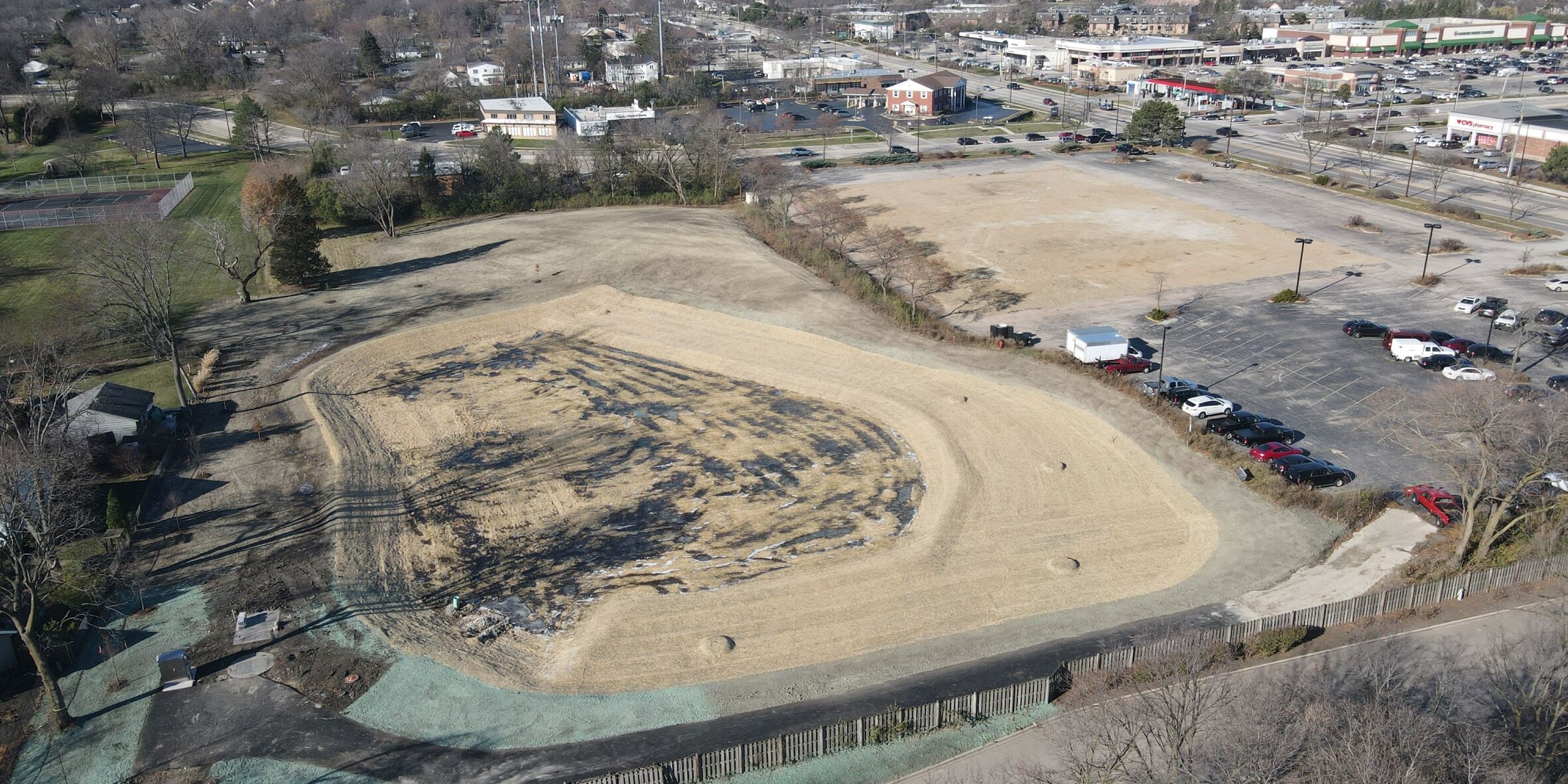An aerial view of a baseball field with dirt and trees.