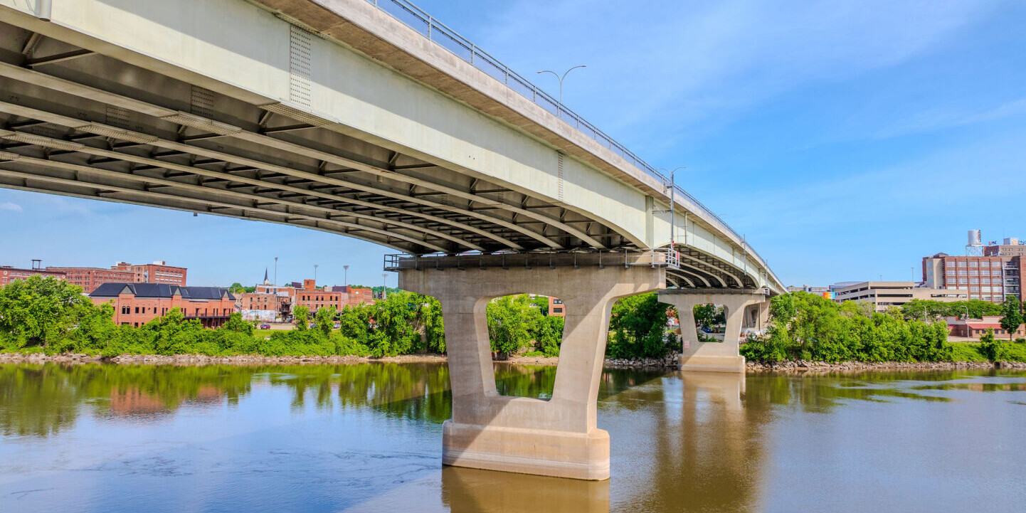 A bridge over water with trees in the background